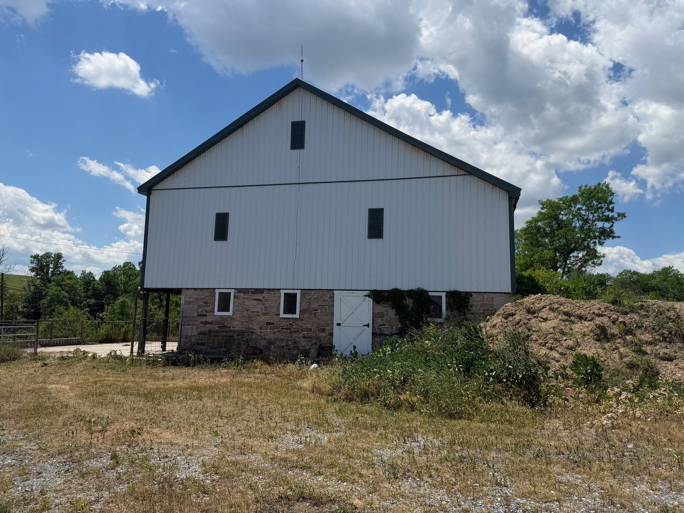 The farm’s white barn and stone lower level, before the planned indoor opening.